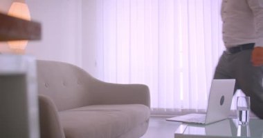 Kapalı ofis memnuniyeti ile kanepede oturarak dizüstü bilgisayarda yazarak yetişkin başarılı kafkas işadamı closeup yan görünüm portresi