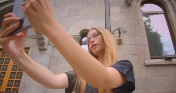 Närbild porträtt av unga vackra kvinnliga med långt hår i glasögon med videosamtal på tablett utomhus på gatan med vinden blåser — Stockvideo
