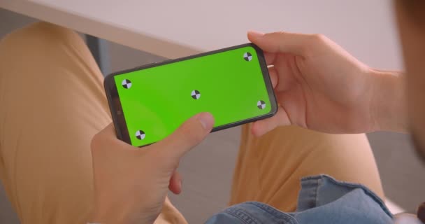 Primo piano vista posteriore ritratto di maschio strisciando sul telefono con schermo verde all'interno — Video Stock