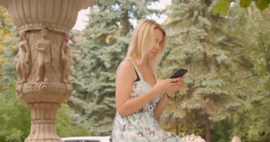 Erkek arkadaşını bekleyen ve dışarıda telefon kullanarak parkta ona sarılmak onu toplantı yetişkin beyaz kadın Closeup portre
