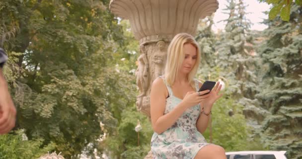 Retrato de close-up de mulher caucasiana adulta esperando seu namorado sentado no parque usando telefone ao ar livre — Vídeo de Stock