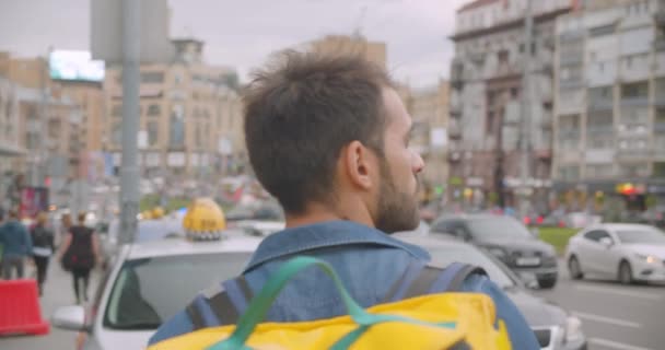 Primer plano vista trasera retrato de adulto caucásico repartidor con mochila caminando en la calle en la ciudad al aire libre — Vídeos de Stock