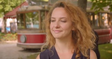 Park açık havada neşeyle gülümseyen kameraya bakan yetişkin oldukça kızıl saçlı kadın Closeup portre