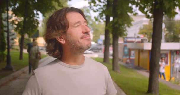 屋外の公園を歩く魅力的な白人男性のクローズアップ肖像画 — ストック動画