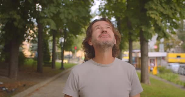 Primer plano retrato de hombre caucásico guapo caminando en el parque al aire libre — Vídeos de Stock