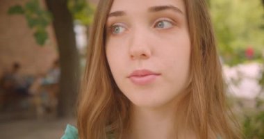 Park açık havada duran kameraya bakan genç güzel beyaz beyaz kadın Closeup portre