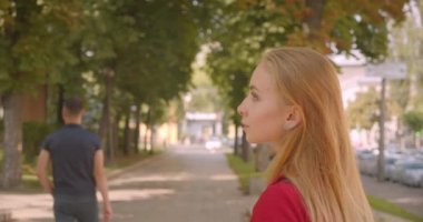 Park açık havada yürüyen genç sarı uzun saçlı güzel kadın Closeup geri görünümü portre