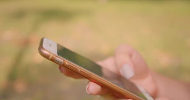 Park açık havada telefon kullanarak genç kafkas kadın ellerin Closeup portre — Stok video