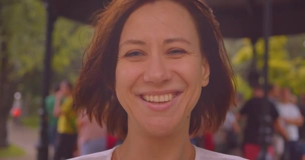 Retrato de close-up de jovem caucasiano feminino olhando para a câmera sorrindo alegremente enquanto chove na cidade urbana ao ar livre — Vídeo de Stock