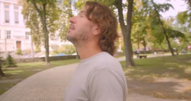 Parkta duran mutlu beyaz adamın havada gezinen kameralı yakın çekim portresi