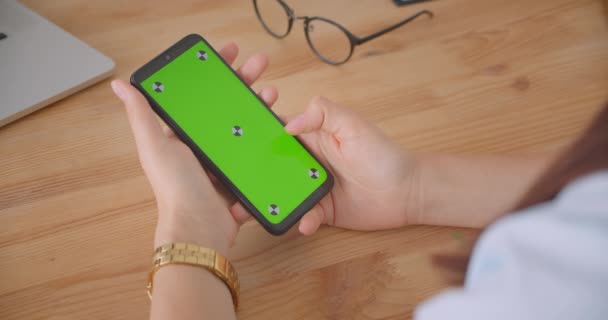 Closeup pohled na portrét mladých lékařů s ručním používáním telefonu se zelenou obrazovkou uvnitř kanceláře — Stock video