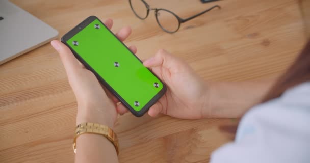 Zbliżenie widok z tyłu portret młodych kobiet lekarzy rękę za pomocą telefonu z zielonym ekranem Chroma wewnątrz w biurze — Wideo stockowe