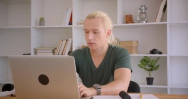 Ofiste dizüstü bilgisayar kullanarak genç çekici sarışın hipster işadamı Closeup portre