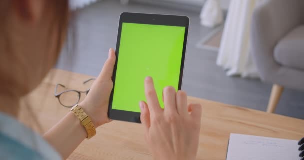 Gros plan vue de dos portrait de jeune médecin caucasienne femme en utilisant la tablette avec écran chromatique vert clé à l'intérieur dans le bureau — Video