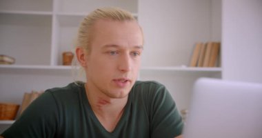 Ofiste dizüstü bilgisayar da görüntülü arama konuşma olan genç çekici sarışın hipster işadamı Closeup portre