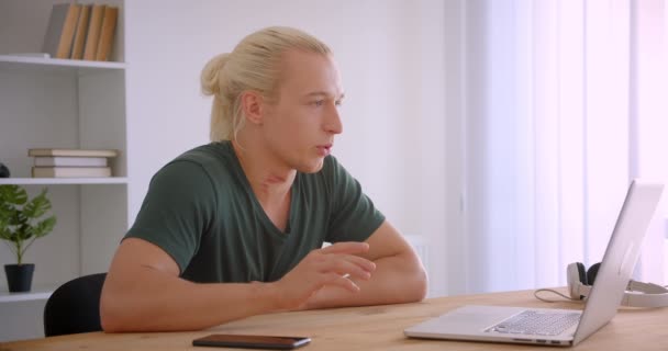 Närbild porträtt av unga attraktiva blonda hipster affärsman med videosamtal på laptop inomhus i Office — Stockvideo