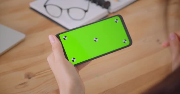 Портрет молодых женщин-врачей, играющих в карты по телефону с зеленым цветным экраном в помещении офиса — стоковое видео