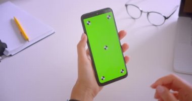 Masa başında ofiste yeşil renk anahtar ekranı ile telefon kullanan kafkas iş kadınlarının yakın çekim portresi