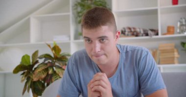 Yetişkin çekici kafkas adam Tv'de spor izlerken ve mutlu kapalı kanepede oturan uzaktan kumanda tutarak kutluyor closeup portre