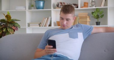 Arka telefonu kullanan yetişkin çekici beyaz adamın kapalı koltukta mutlu bir şekilde otururken ki yakın çekim portresi