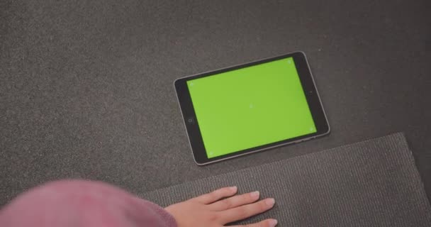 Closeup portrait of young determined athletic female doing plank exercise using tracking app on phone with green chroma screen in gym — Stock Video