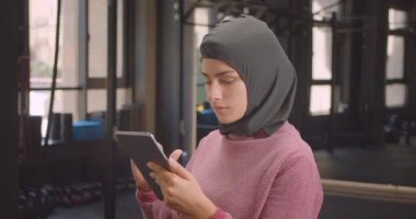 Spor salonunda tablet kullanarak hijab genç atletik Müslüman kadın Closeup portre kapalı
