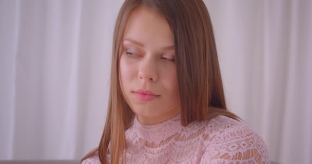 Zbliżenie portret młodego cute kaukaski kobieta patrząc na aparat z ufnością w pomieszczeniu w mieszkaniu — Wideo stockowe