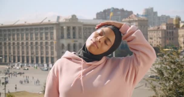 Closeup retrato de jovem atraente afro-americano muçulmano menina alongando-se na cidade ao ar livre — Vídeo de Stock