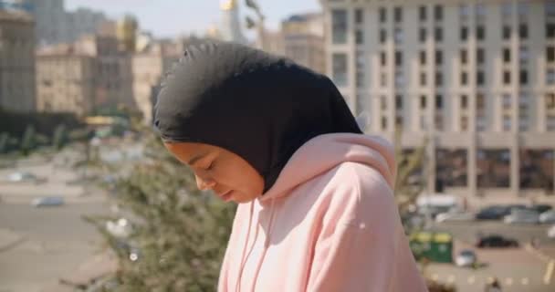 Closeup portrait of young attractive african american muslim girl stretching in urban city outdoors — Stock Video