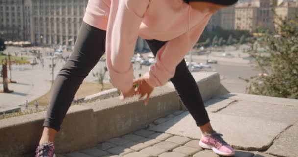 Closeup portrait of young attractive african american muslim girl in hijab stretching in urban city outdoors — Stock Video