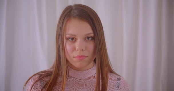 Close-up portret van jonge schattige Kaukasische meisje dansen gelukkig in de voorkant van de camera binnenshuis in een gezellig appartement — Stockvideo