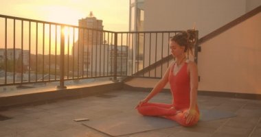 Arka planda güzel şehir manzara gün batımı ile çatı üzerinde yoga lotus pratik dreadlocks ile manevi kadın Closeup portre