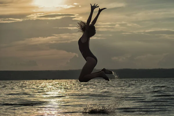 Vacker Flicka Hoppar Mot Bakgrund Solnedgången — Stockfoto