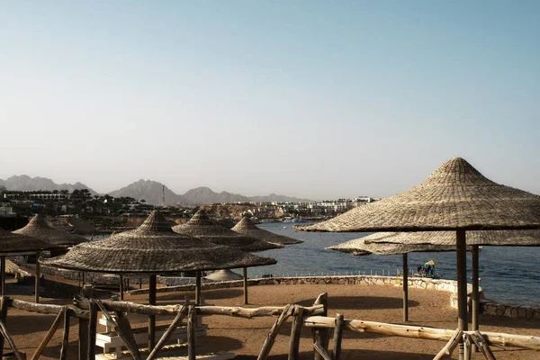 Sahilde şemsiyelerle deniz manzarası çok güzel.