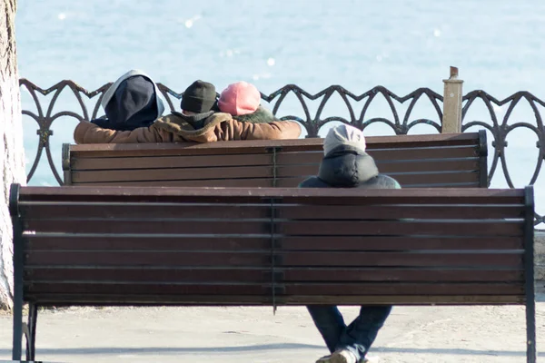 company of people relaxing on the benches against the backdrop of the sea, ocean. love story, broken heart