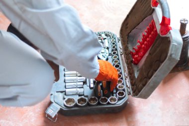 Atölyede tamirci aletleriyle çalışan bir adam.