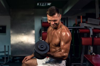 Spor salonundaki parmaklıklar üzerinde egzersiz yapan kaslı vücut geliştirici. Spor salonunda karın kası eğitimi almış yakışıklı, sportif ve seksi bir adam. fitness, vücut geliştirme, beslenme, sağlıklı yaşam tarzı