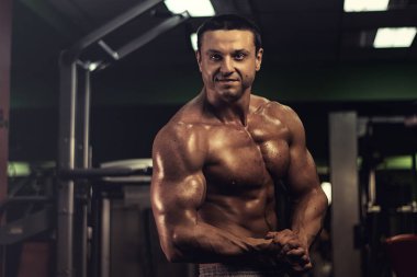 Spor salonundaki parmaklıklar üzerinde egzersiz yapan kaslı vücut geliştirici. Spor salonunda karın kası eğitimi almış yakışıklı, sportif ve seksi bir adam. fitness, vücut geliştirme, beslenme, sağlıklı yaşam tarzı