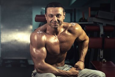 Spor salonundaki parmaklıklar üzerinde egzersiz yapan kaslı vücut geliştirici. Spor salonunda karın kası eğitimi almış yakışıklı, sportif ve seksi bir adam. fitness, vücut geliştirme, beslenme, sağlıklı yaşam tarzı