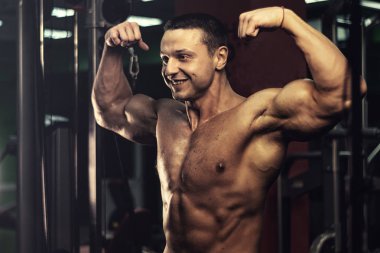 Spor salonundaki parmaklıklar üzerinde egzersiz yapan kaslı vücut geliştirici. Spor salonunda karın kası eğitimi almış yakışıklı, sportif ve seksi bir adam. fitness, vücut geliştirme, beslenme, sağlıklı yaşam tarzı