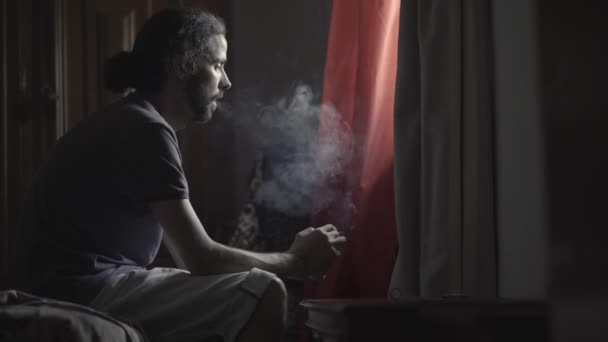 男は窓の横にある部屋での喫煙 — ストック動画