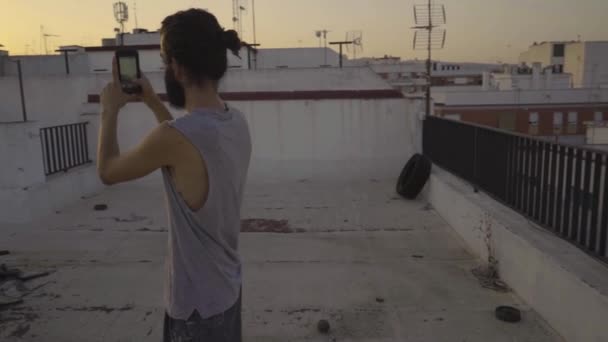 Чоловік Фотографує Смартфоном Даху Під Час Заходу Сонця — стокове відео