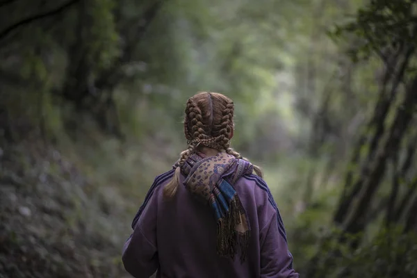 Back of a woman walking through the woods