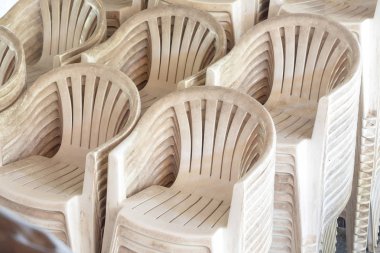 Birçok eski ve beyaz plastik sandalyeler açık yığını.