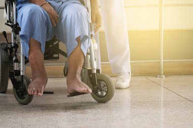 Bir elektrikli tekerlekli sandalye hastanede hemşire ile Engelli yaşlı adam.