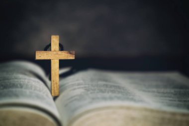 Ahşap çapraz işareti simgesi ve İncil'de sabah özveri ile Tanrı'ya dua.