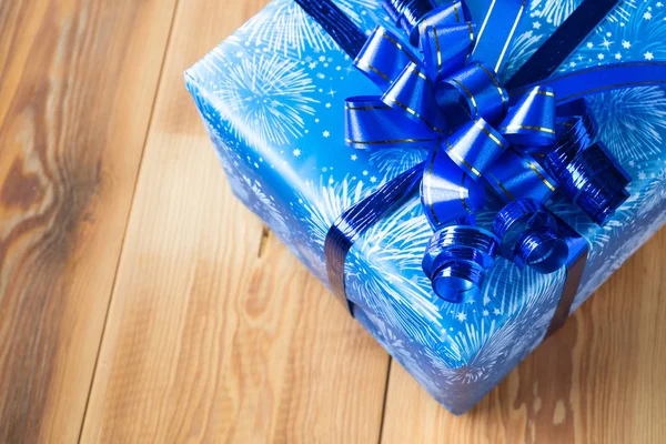 Blue Gift Box with Dark Blue Ribbon on the Wood Table.