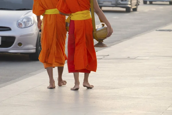 Buddhistische Mönche gehen morgens in der Stadt entlang der Straße. — Stockfoto