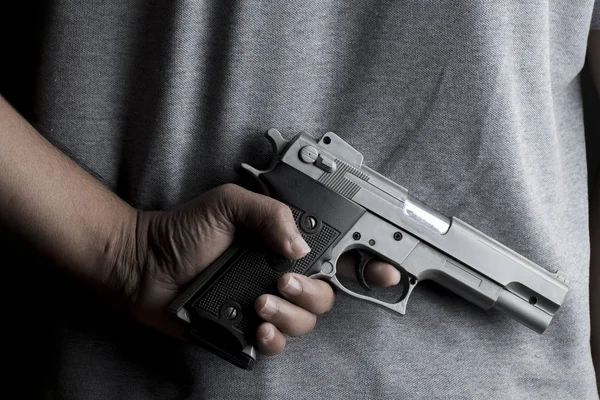 Un hombre llevando una pistola de juguete para robar el dinero. Imagen del concepto . —  Fotos de Stock