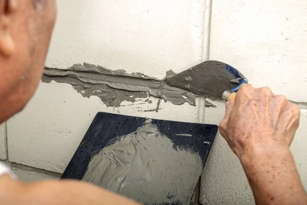 Skicklig gammal man Plasterer puts cement på den gamla tegel — Stockfoto